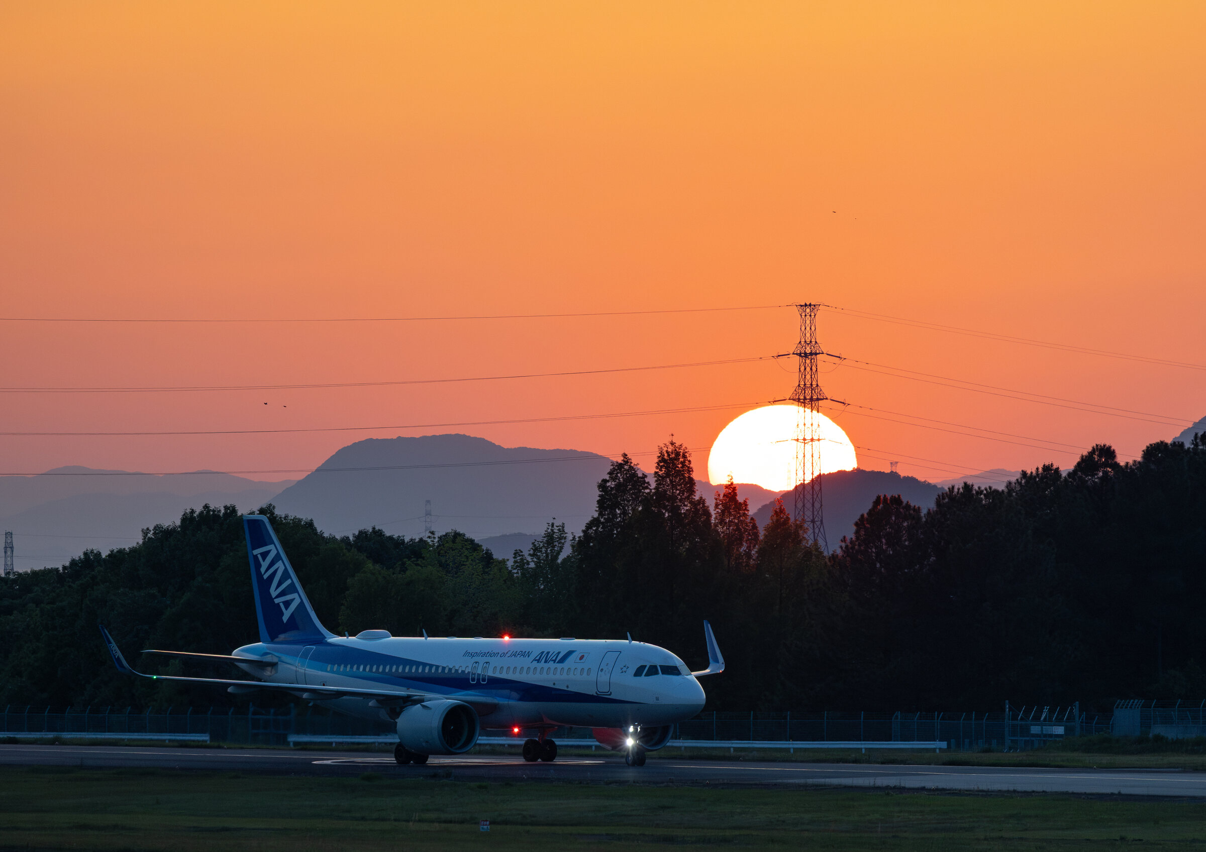 夕日を背景に地上走行するANAの機体